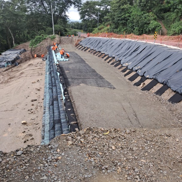 Muro en suelo reforzado durante la etapa de construcción con instalación de geosintéticos y compactación del relleno